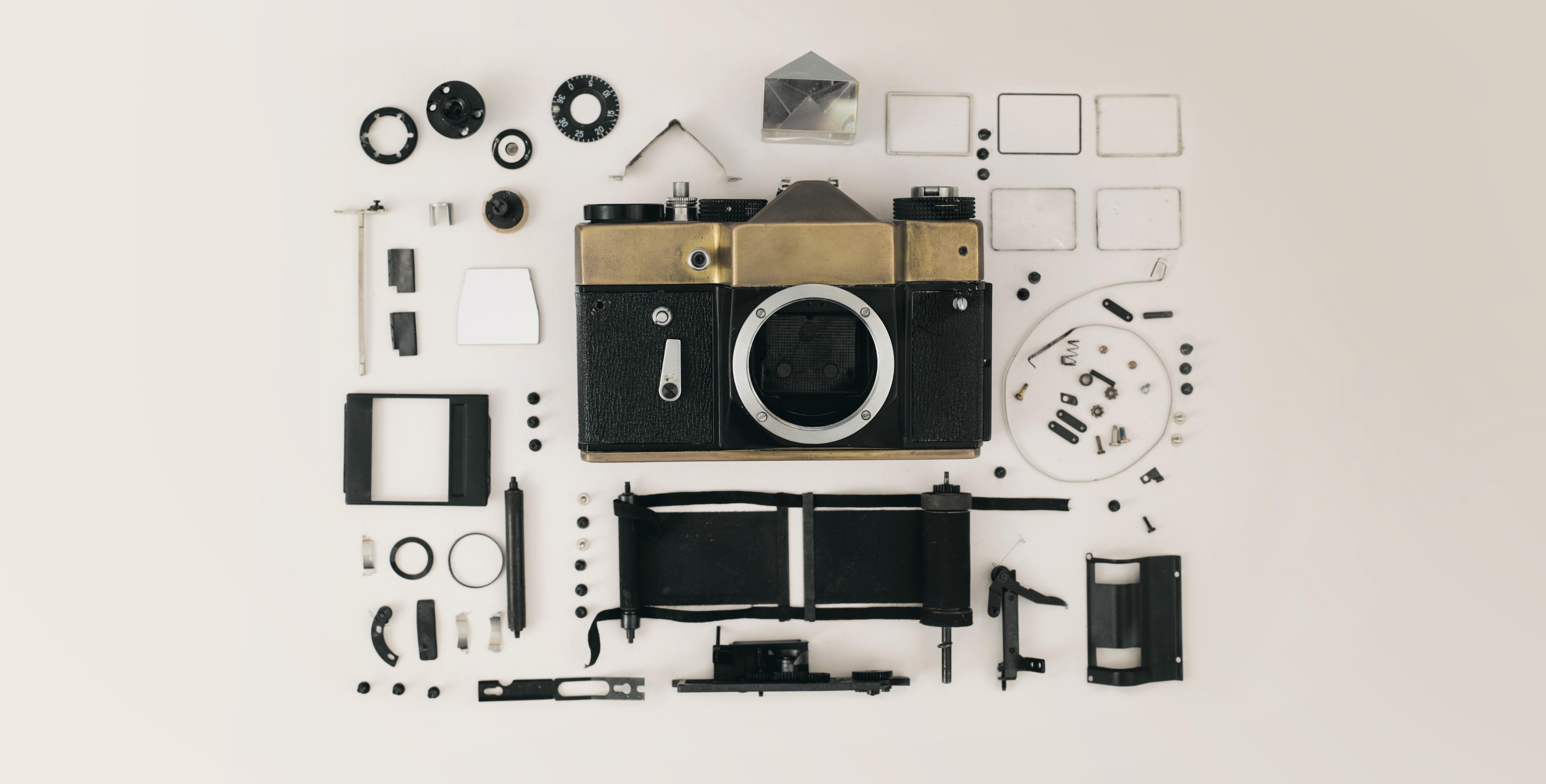 The parts of a DSLR camera laid out in a satisfying arrangement.