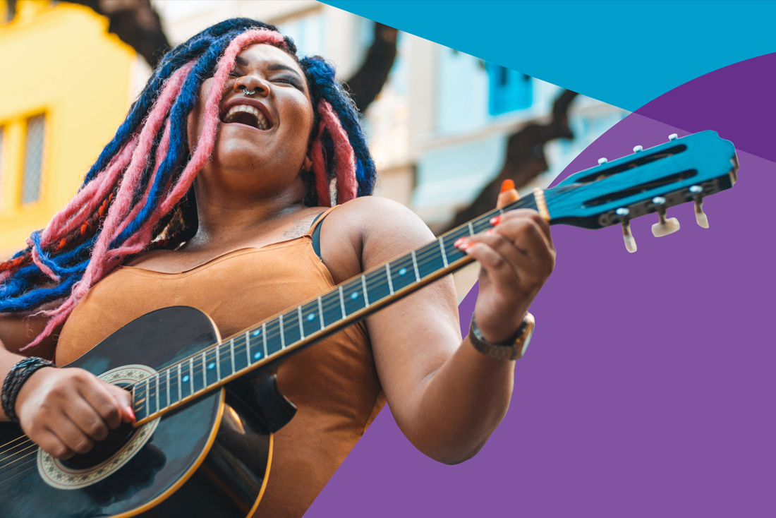 person emphatically singing and playing the guitar