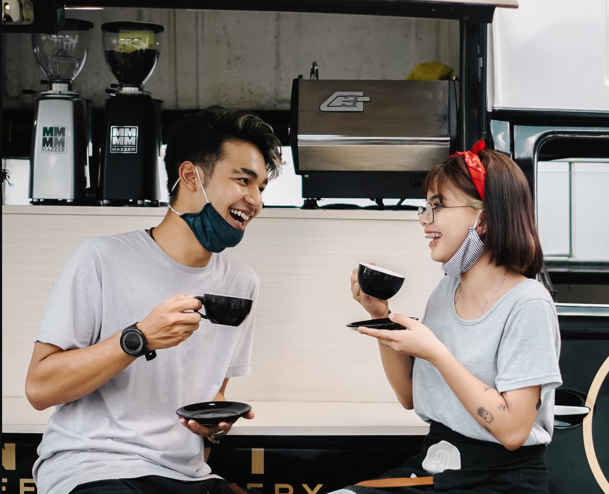 A very stock photo-like shot of two people having what appears to be a hilarious conversation over coffee.