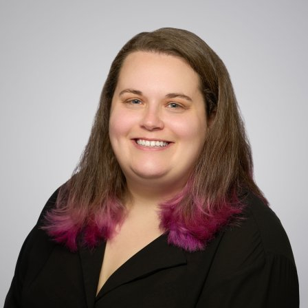 Frances, a white woman with brown hair and purple highlights smiling.